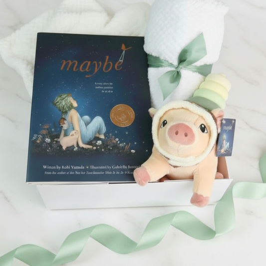Plush pig toy with a book titled 'maybe' on a white background