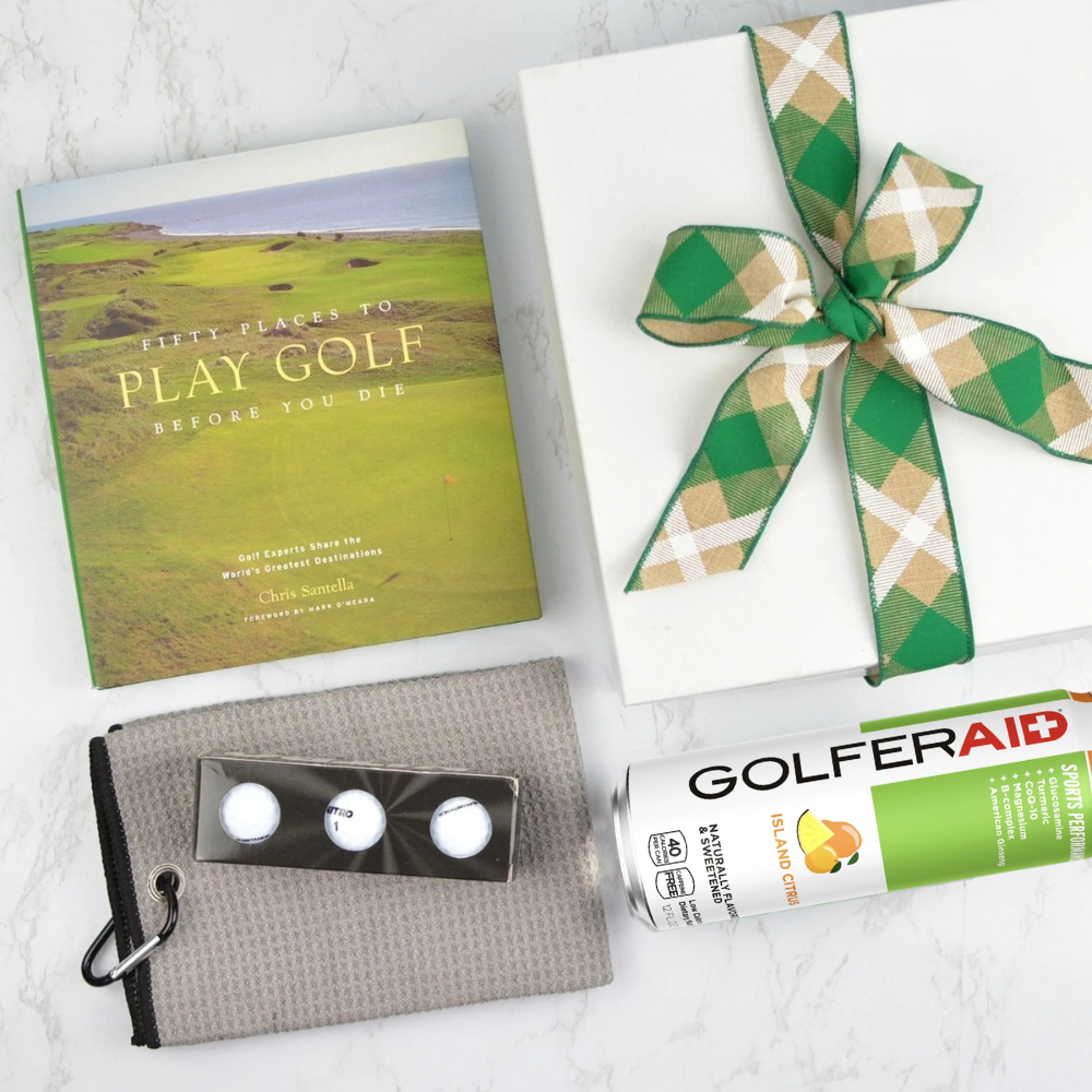 Gift box with a green and white checkered bow, golf book, golf balls, and GolferAid tube on a light surface.